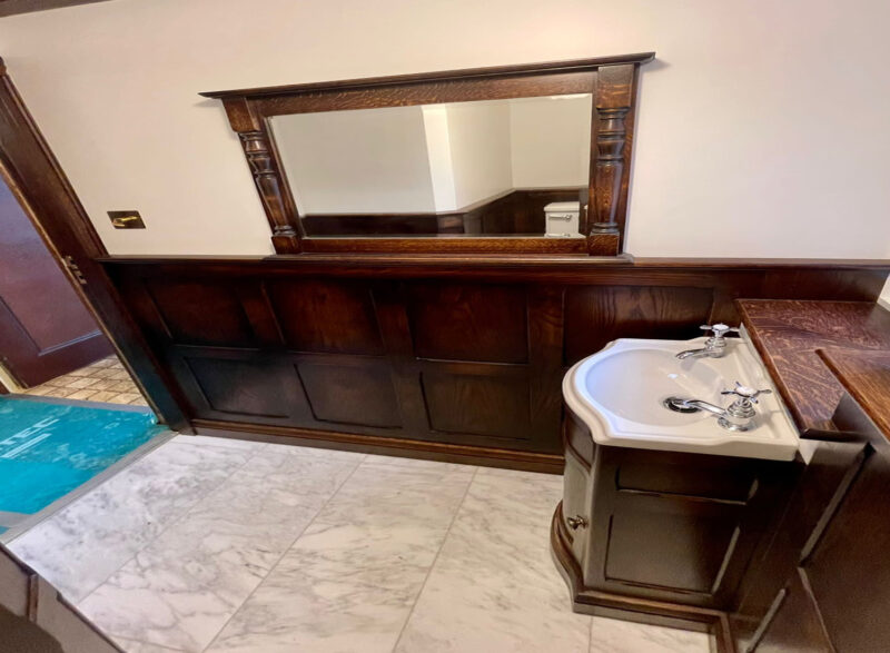 Oak bathroom panelling with a curved vanity unit, by Old Fashioned Bathrooms