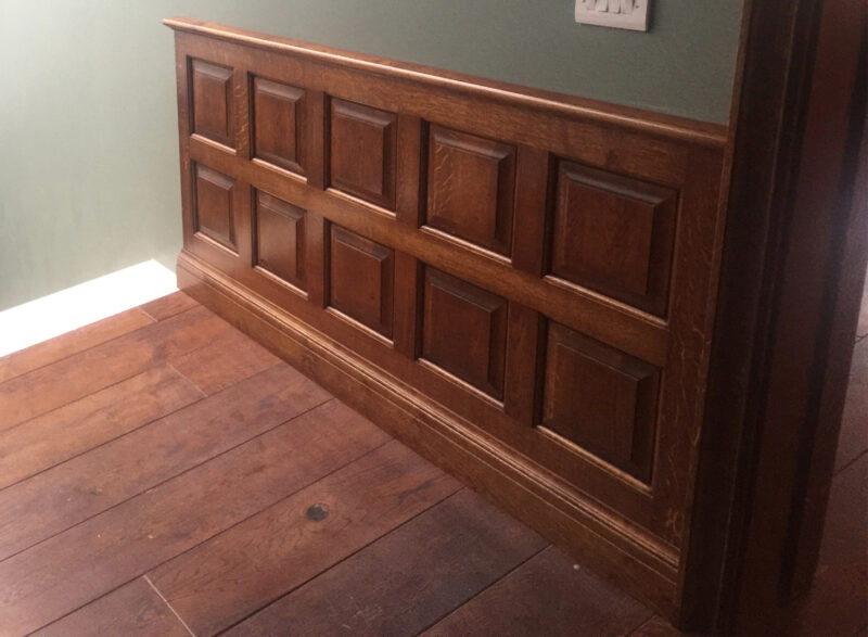A room lined with raised and fielded oak panelling, made and fitted by Reeve & Co Interiors