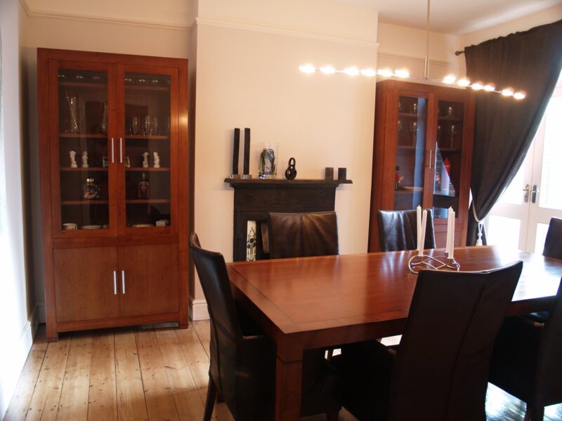 Deco dining room with a long polished table, leather chairs and matching glazed cabinets