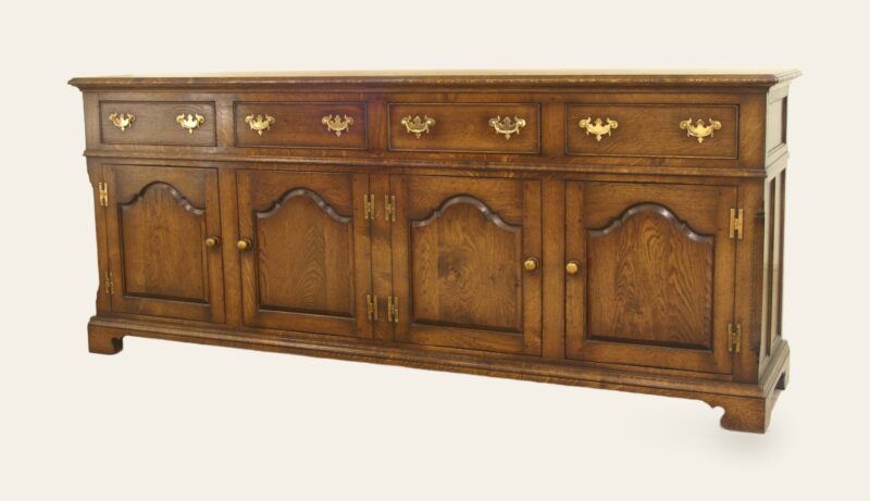 Four door drawer dresser base shaped fielded doors, angle view — handmade by Bryn Hall in Suffolk